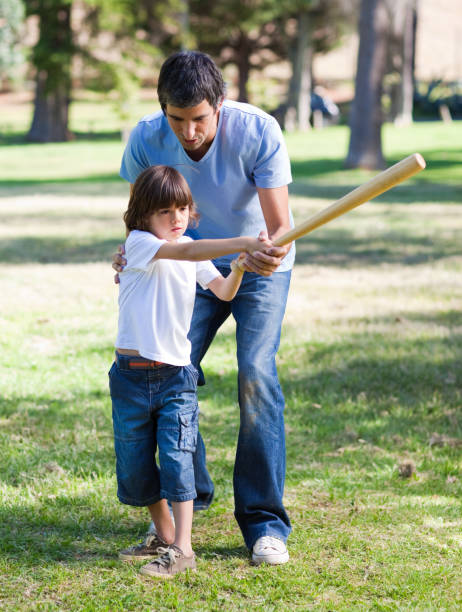 istock Positive father teaching baseball to his son 856269376