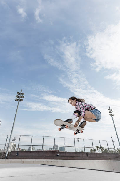 istock Young woman jumping with skateboard 856270120