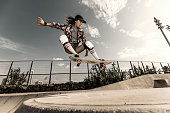Young woman jumping with skateboard