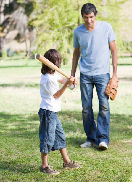 istock Cute little boy playing baseball with his father 856273414