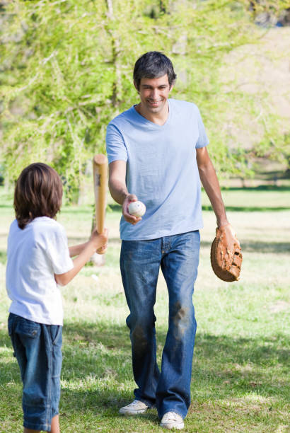 istock Adorable little boy playing baseball with his father 856273462
