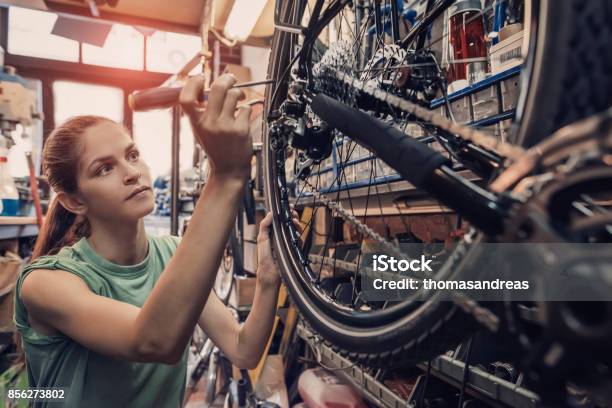 Frau Fahrradmechaniker Ist Eine Fahrrad In Der Werkstatt Reparieren Stockfoto und mehr Bilder von Fahrrad
