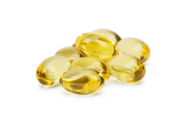 istock Cod liver oil omega 3 gel capsules or pils isolated on a white background. A group of transparent fish oil tablets. 856283288