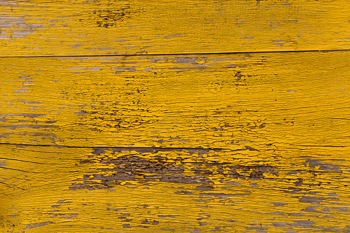 Vintage yellow wood background with peeling paint.