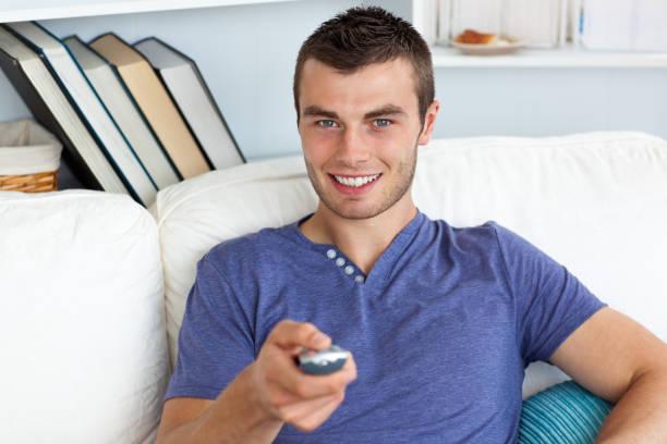 istock Smiling man relaxing in the livingroom watching television 856289368