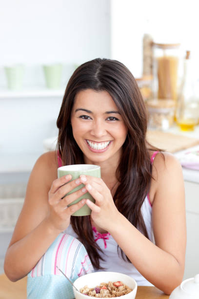 istock Cute woman holding a cup a coffee in the kitchen 856297840
