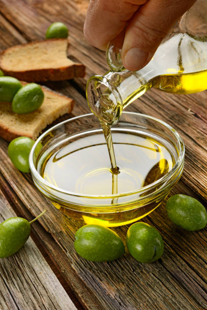 istock pour olive oil into glass bowl 856310640