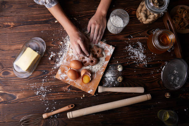 istock Hands with chocolate cookies next to ingredients on a table background. Cookies cooking concept. 856314902