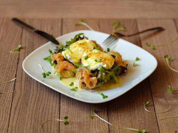 istock Top view of benedict eggs on a wooden background. Baked eggs wit 856315136