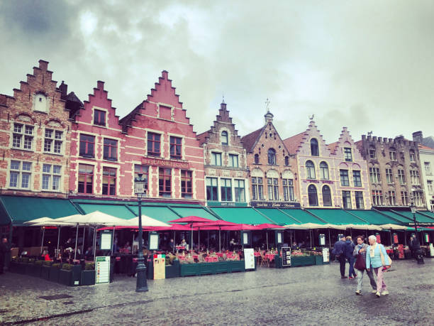 bruges, praça markt com cafés e turistas visitando lugares turísticos, bélgica - bruges cityscape europe autumn - fotografias e filmes do acervo