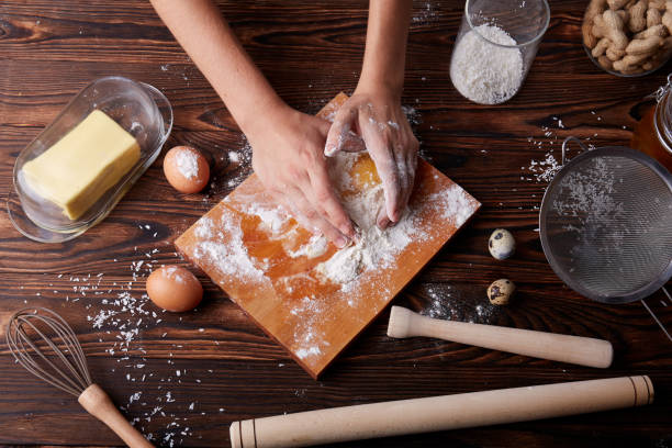istock Top view of hands holding a cracked egg with yolk on a table background. Baking and dough making. 856318292