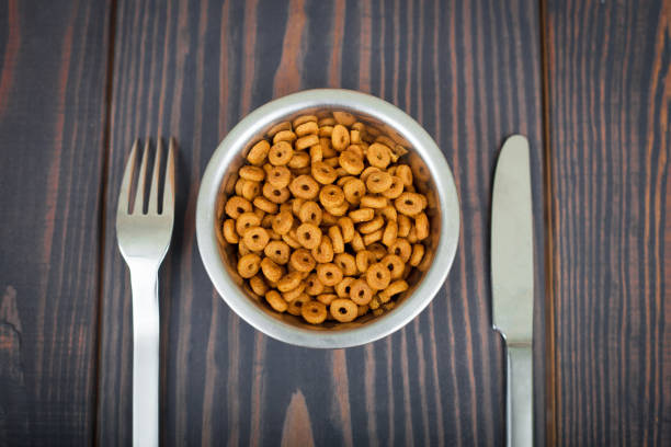 istock Cat food and cutlery on a wooden table. 856330836