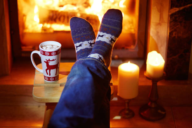 istock Man's feet in warm socks near fireplace 856335552