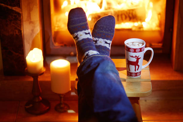 istock Man's feet in warm socks near fireplace 856335584