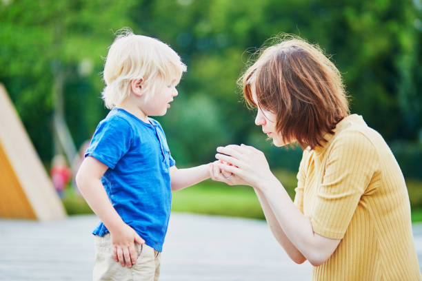 Mother comforting son after he injured his hand Mother comforting her son after he injured his hand sliver stock pictures, royalty-free photos & images