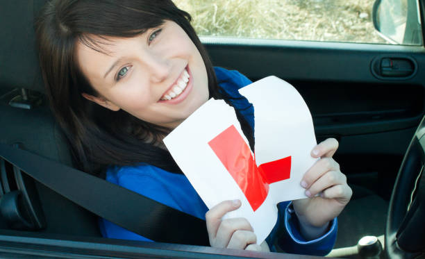 istock Cheerful young female driver tearing up her L sign 856362956
