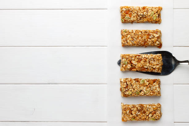 Homemade no bake granola bars on white wooden background. stock photo