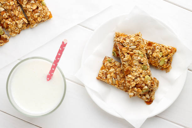 istock Healthy breakfast with granola bars and milk on white wooden table. 856365840