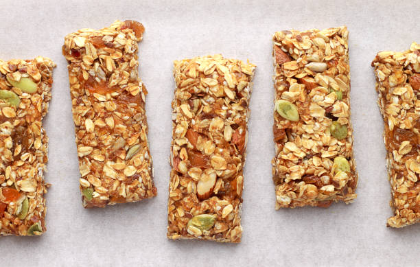 Homemade granola bars on white baking paper. stock photo