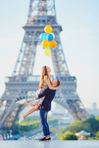 couple with colorful balloons near the eiffel tower - paris france eiffel tower love kissing imagens e fotografias de stock