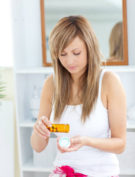 istock Serious woman taking pills in the bathroom 856372140