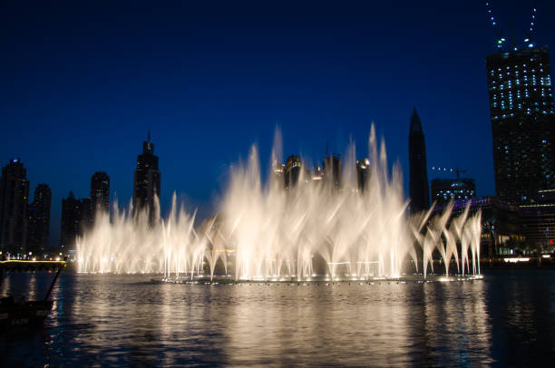 Dubai Fountain Illuminated water fountain in Dubai in the evening with dark blue sky dubai mall stock pictures, royalty-free photos & images