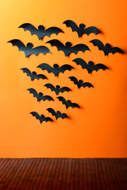 istock A flock of paper bats on the orange wall 856379476