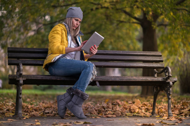 istock pretty women in the park with her touchpad 856388638