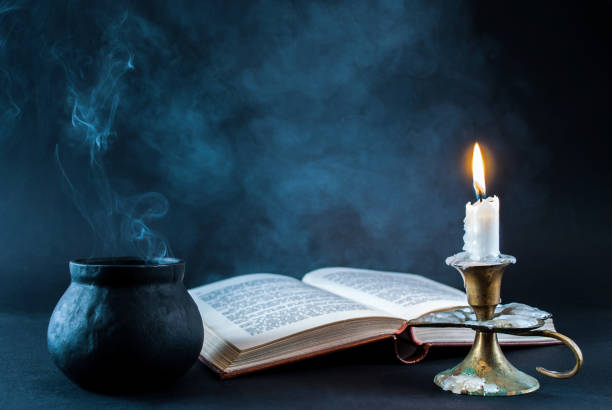 candle in candlestick burning and old wooden box and on dark and smoked background - candlestick holder fotos imagens e fotografias de stock