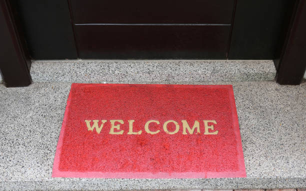 istock welcome text on red doormat in front of door room. 856403786