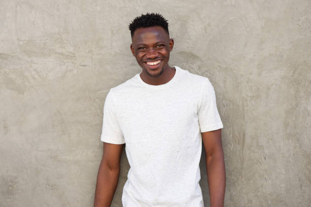 istock happy young african american man smiling by wall 856404020