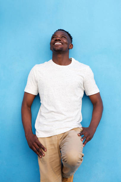 istock handsome african american man against blue wall and looking up 856404220