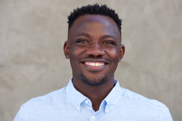 istock smiling young african american man standing against a wall 856406844