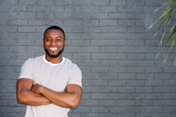 istock smiling handsome man standing with arms crossed 856406910