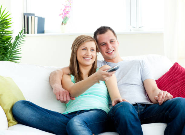 istock Charismatic man embracing his girlfriend while watching tv 856407548