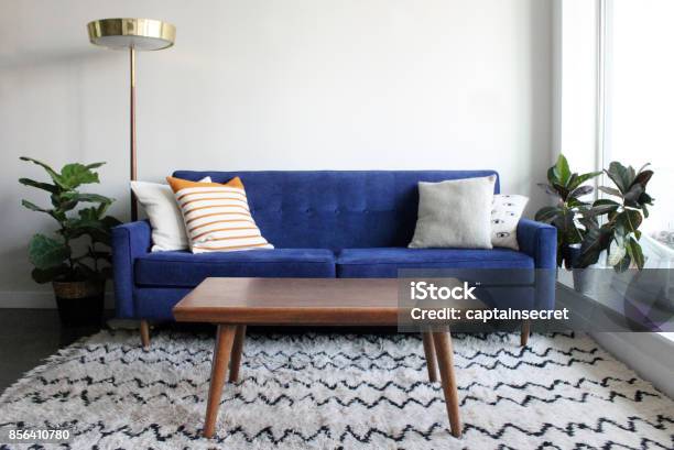 Blue Suede Mid Century Modern Couch In Minimalist Apartment Setting Stock Photo - Download Image Now