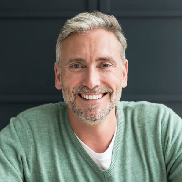istock Portrait of man in his 40s with grey hair and beard smiling towards camera 856410942