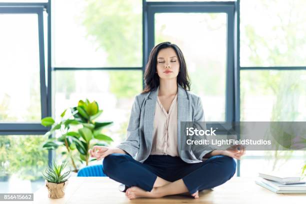 Businesswoman Meditating At Workplace Stock Photo - Download Image Now - Women, One Woman Only, Mindfulness