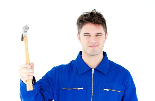 istock Smiling mechanic holding a hammer looking at the camera 856427386