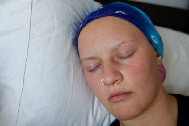 Close up of cancer patient with headscarf sleeping stock photo