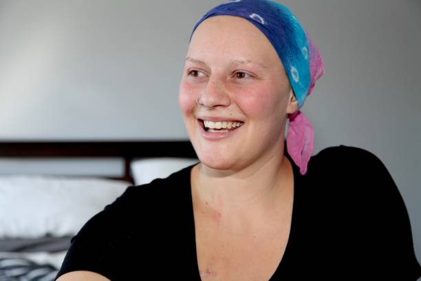 Young cancer patient in a headscarf smiles stock photo