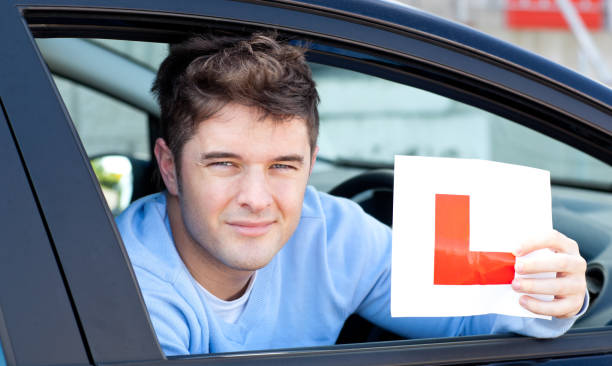 istock Positvie young male driver holding a L sign 856427646