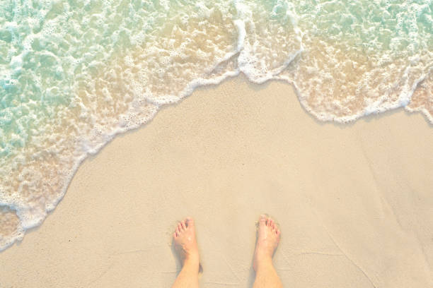 素足で砂浜の白澄んだ水浜に立って、タイのプーケット島で私の足を - flip flop human foot sand women ストックフォトと画像
