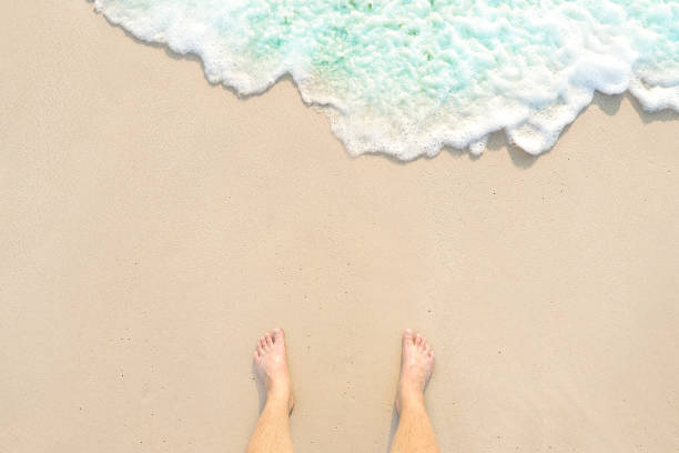 istock bare foot standing on the white clear water sandy beach and looking to my feet at Phuket island in Thailand 856438416