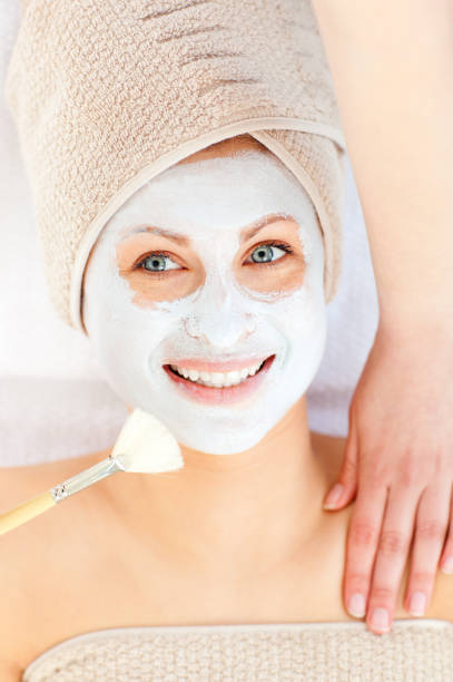 istock Radiant young woman having white cream on her face 856438808