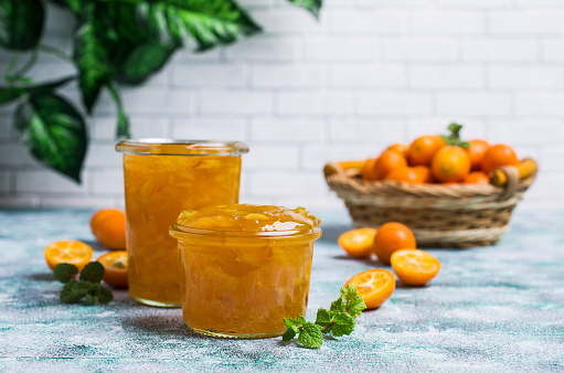 Jam from kumquat with rind in glass on a wooden background. Selective focus.