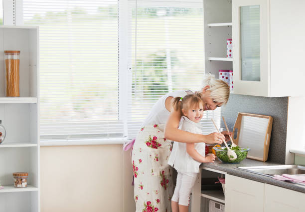 istock Jolly girl preparing a salad with her mother 856452078