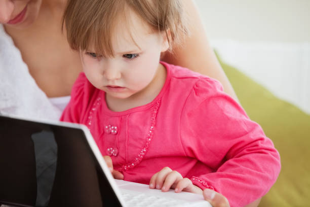 istock Close up of a facinated girl using a laptop with her mother 856454766