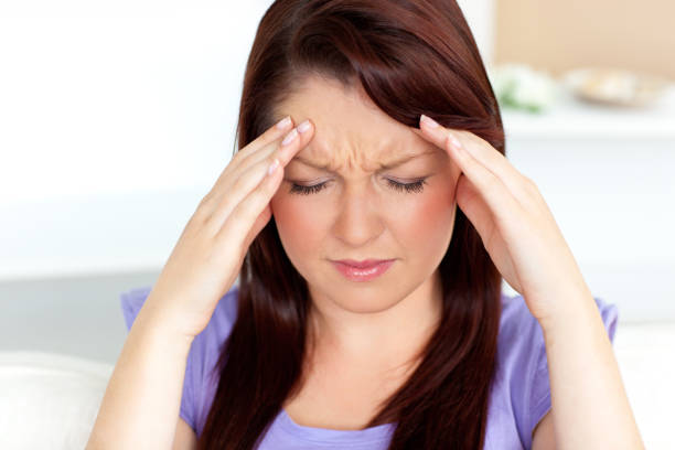 istock Young woman with headache at home 856455380