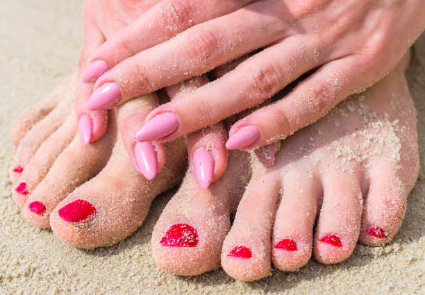 istock Close-up of woman's feet and woman's hands in sand. Selective focus. 856455704